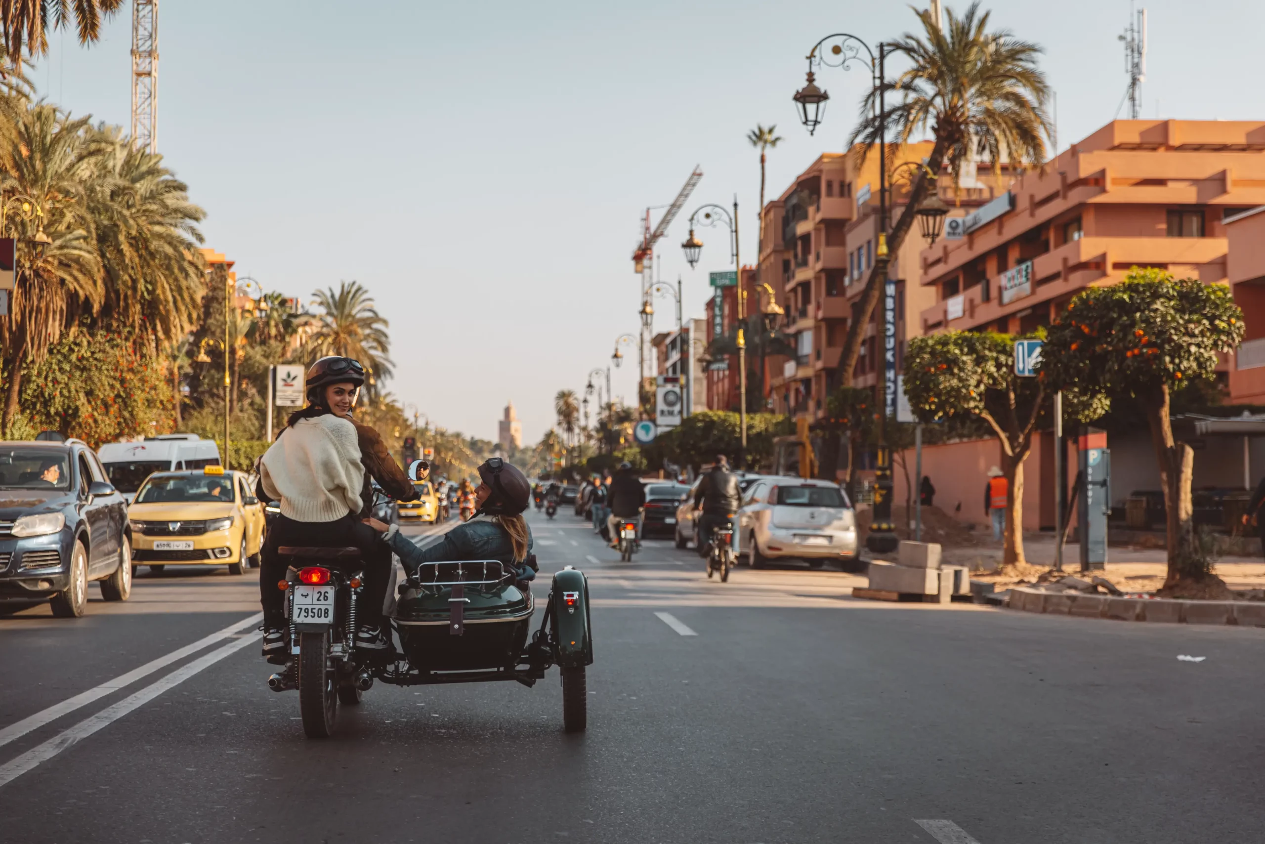 Side-car riding down a palm-lined avenue in the Gueliz district of Marrakech