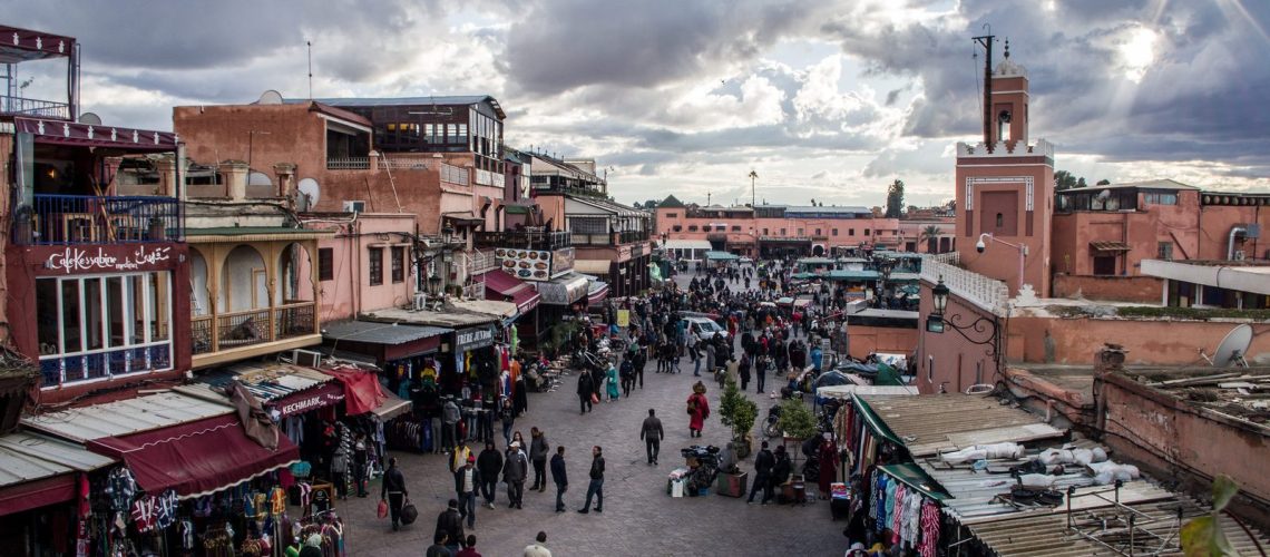 Voyageuse habillée en couches légères et matières naturelles dans une ruelle ensoleillée de la médina de Marrakech